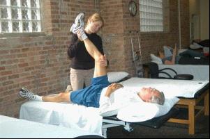 caregiver stretching the senior man